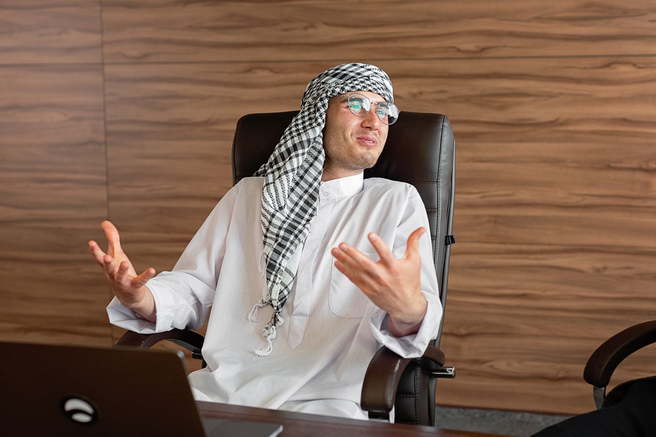 رائد أعمال سعودي بالثوب في مكتب بالرياض يراجع متجره الإلكتروني وتحليلات Google