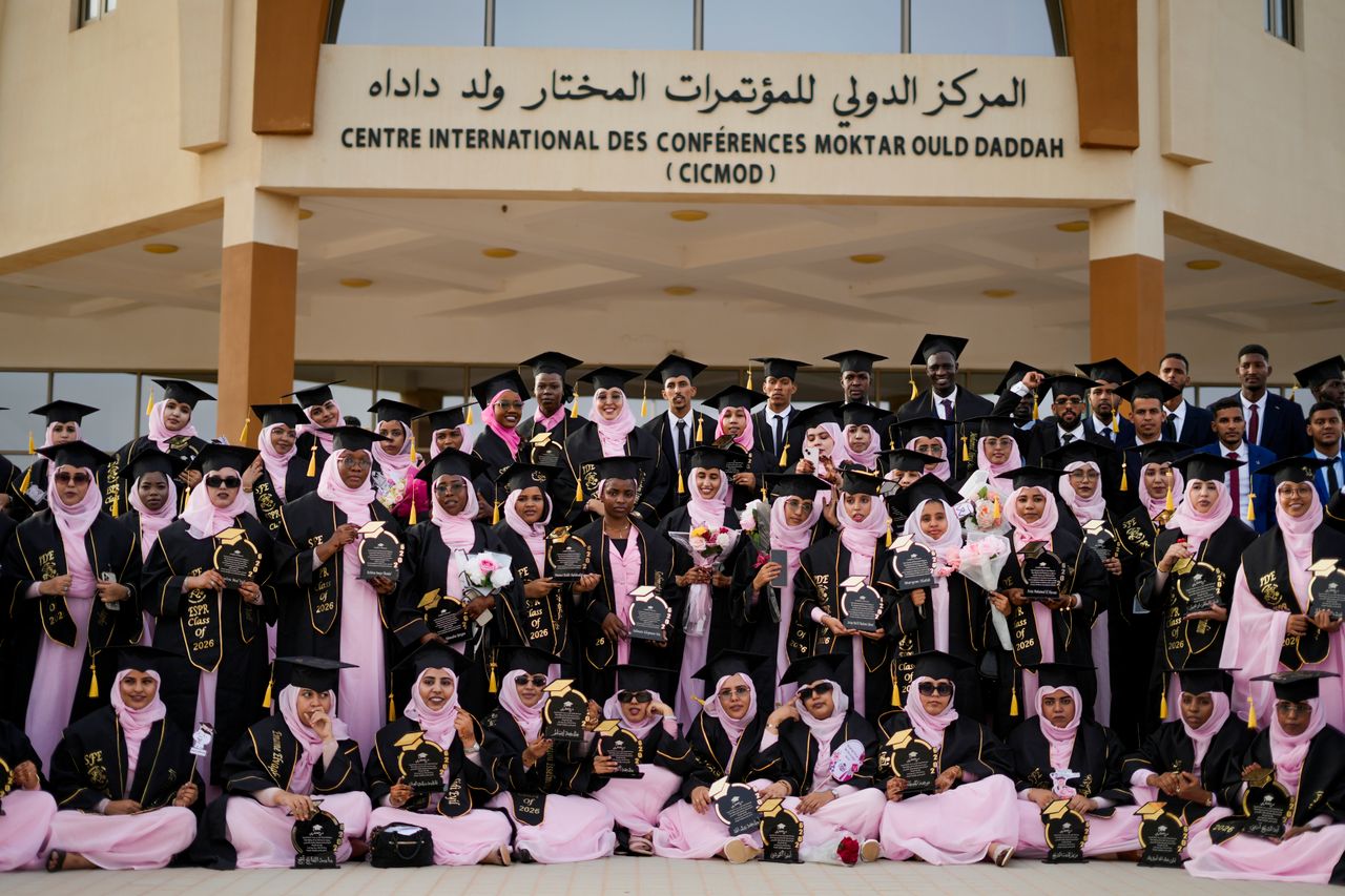 حفل تخرج سعودي رسمي في الرياض مع خريجين بالزي الرسمي ومصورين محترفين أمام المسرح