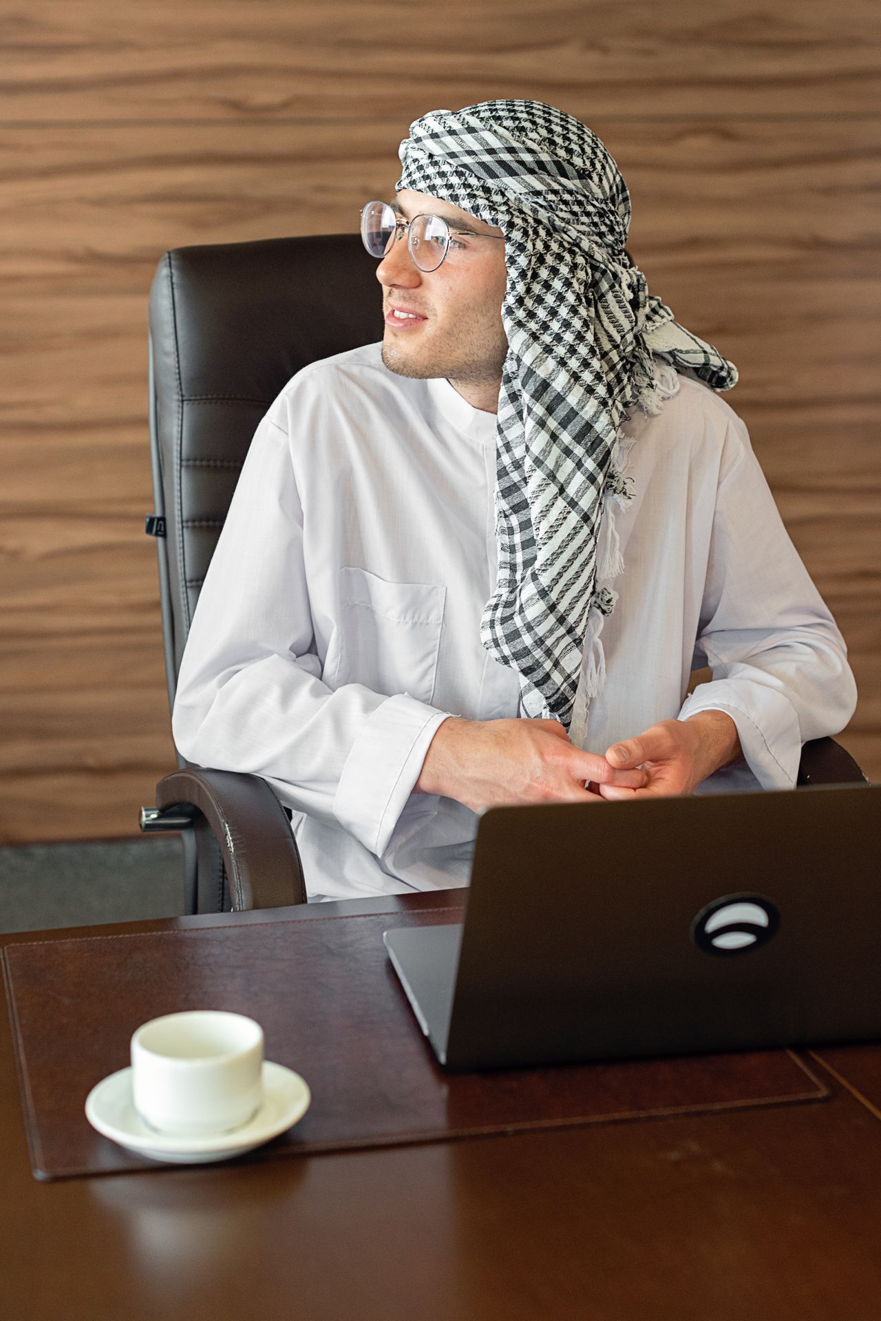 فريق مبيعات وتسويق سعودي بالثوب والغترة يراجع لوحة عملاء محتملين ونقاط Lead Scoring في مكتب بالرياض