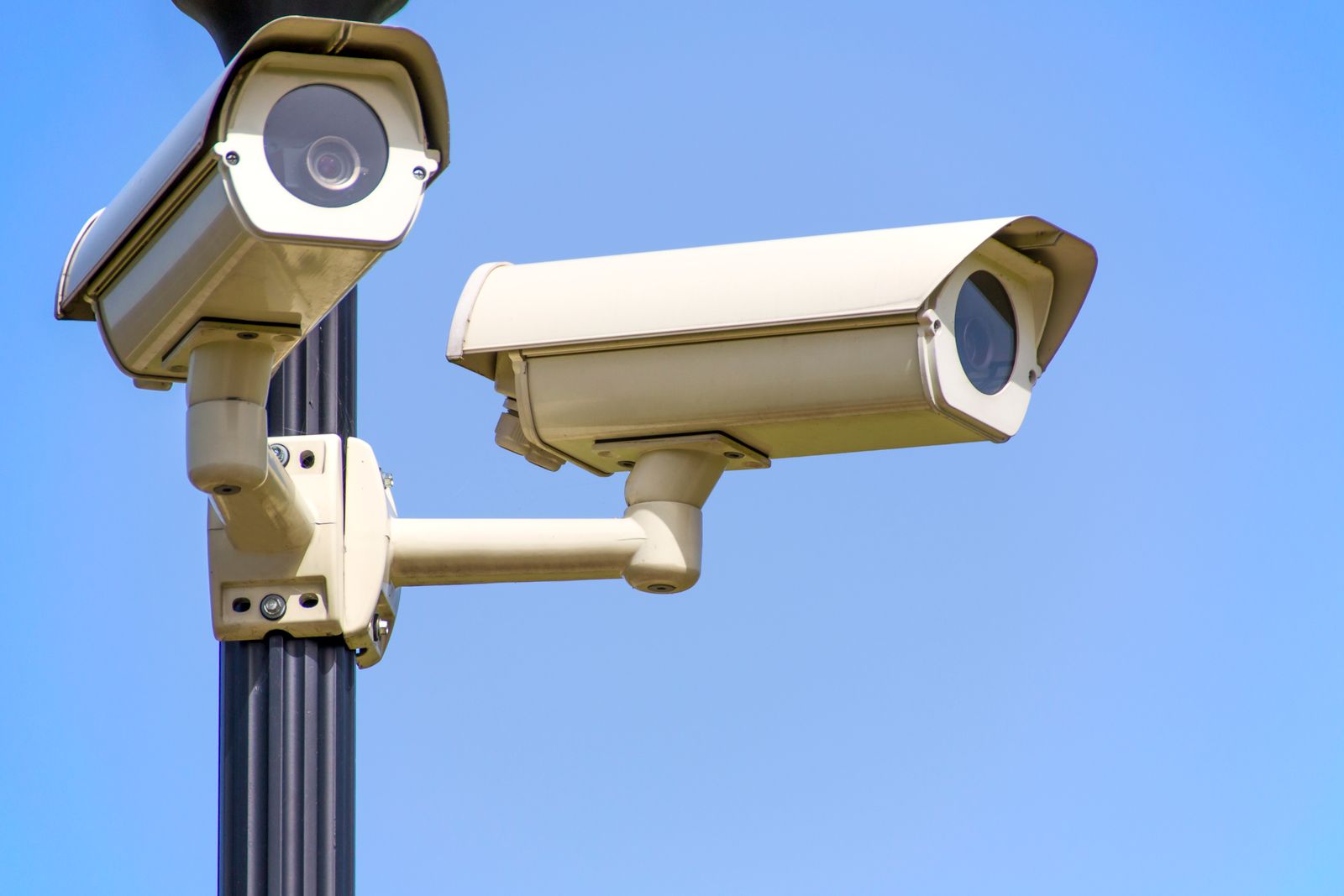 كاميرا مراقبة خارجية مثبتة على جدار ليلا بإضاءة صفراء توضح مراقبة المزارع ليلا